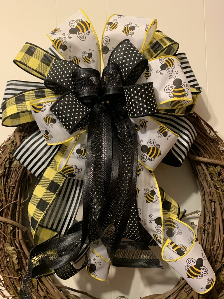 Large multi-loop bow with yellow, white, and black complimenting ribbons